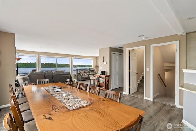 dining area featuring stairs, baseboards, and dark wood-style flooring