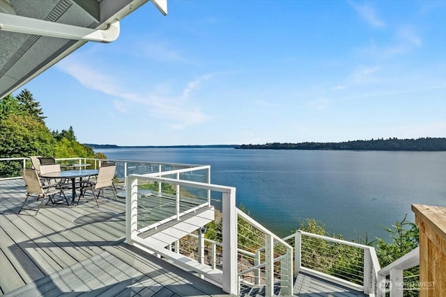 exterior space with outdoor dining area and a water view