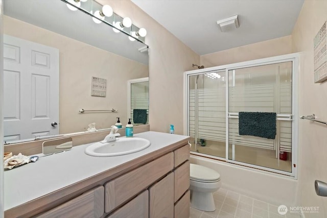 full bath featuring enclosed tub / shower combo, toilet, vanity, and tile patterned flooring