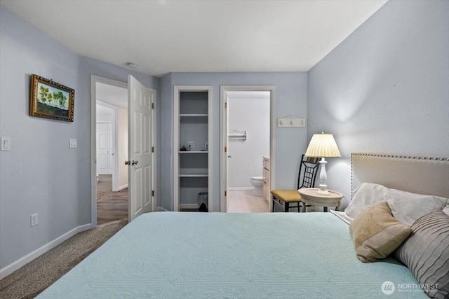 bedroom with ensuite bath, carpet, and baseboards