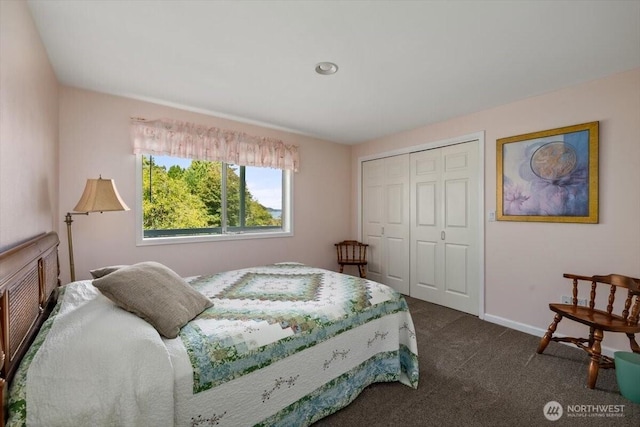 bedroom featuring dark colored carpet, a closet, and baseboards