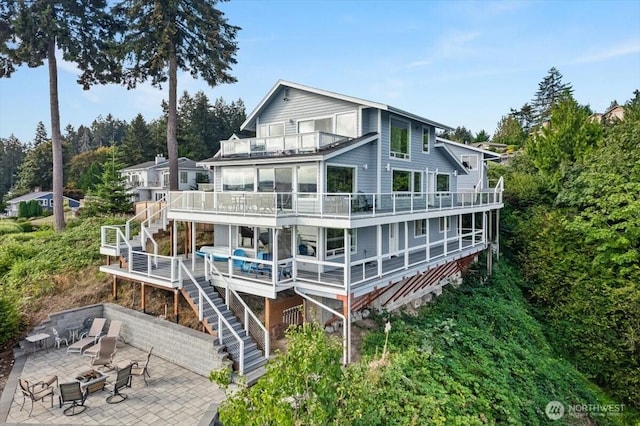 back of property with a patio area, stairway, an outdoor fire pit, and a balcony