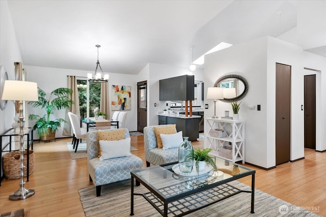 living area featuring an inviting chandelier, light wood-type flooring, and lofted ceiling