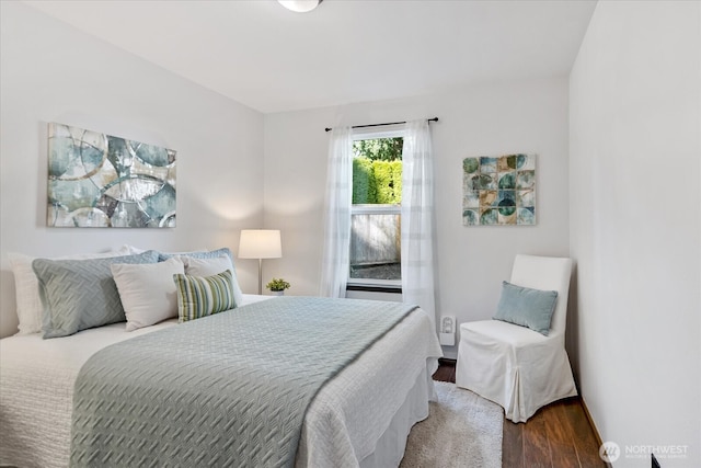 bedroom with baseboards and wood finished floors