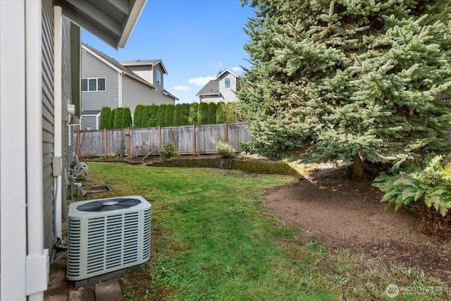 view of yard featuring fence and central AC