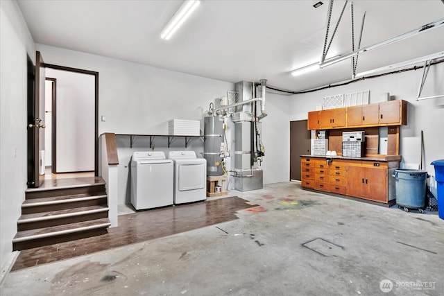 garage with heating unit, secured water heater, and separate washer and dryer