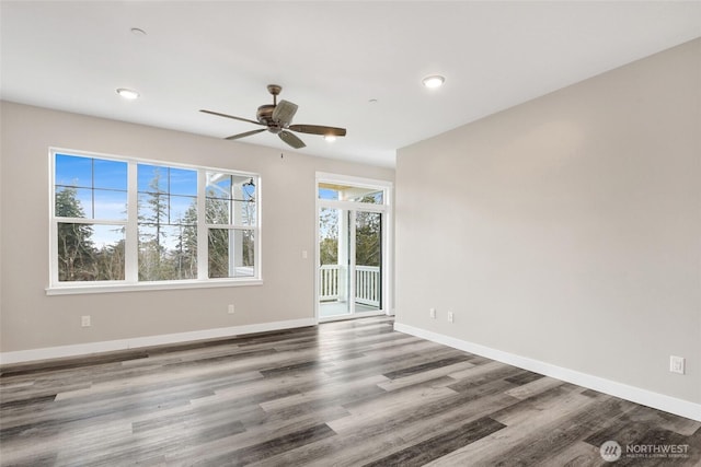 empty room with baseboards, wood finished floors, and a ceiling fan