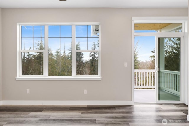 spare room featuring baseboards and wood finished floors