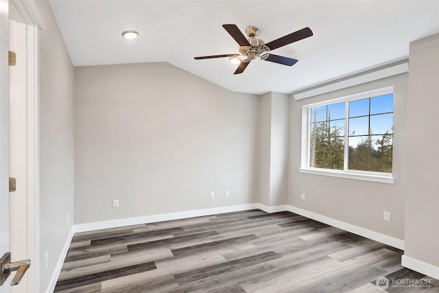 spare room with vaulted ceiling, baseboards, a ceiling fan, and wood finished floors