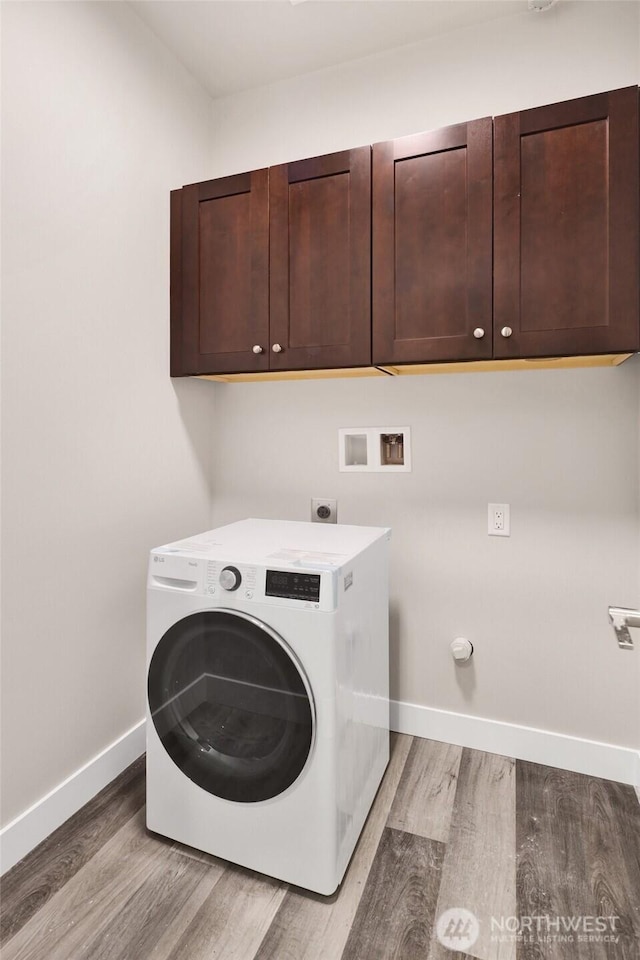 laundry room featuring light wood-style floors, washer / dryer, cabinet space, and baseboards