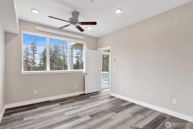 empty room featuring recessed lighting, baseboards, wood finished floors, and a ceiling fan