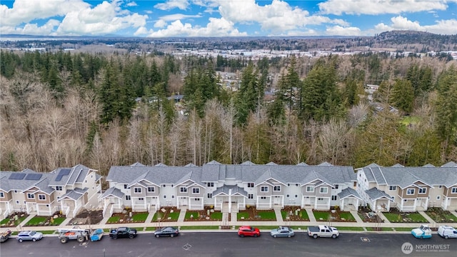 aerial view featuring a wooded view and a residential view