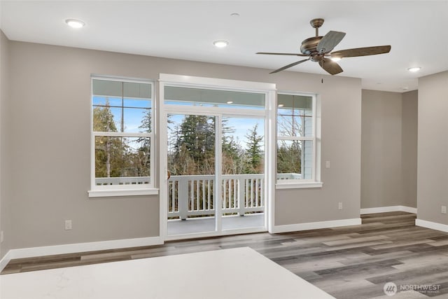 empty room with recessed lighting, a ceiling fan, baseboards, and wood finished floors