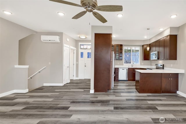 kitchen with baseboards, an AC wall unit, light countertops, wood finished floors, and stainless steel appliances