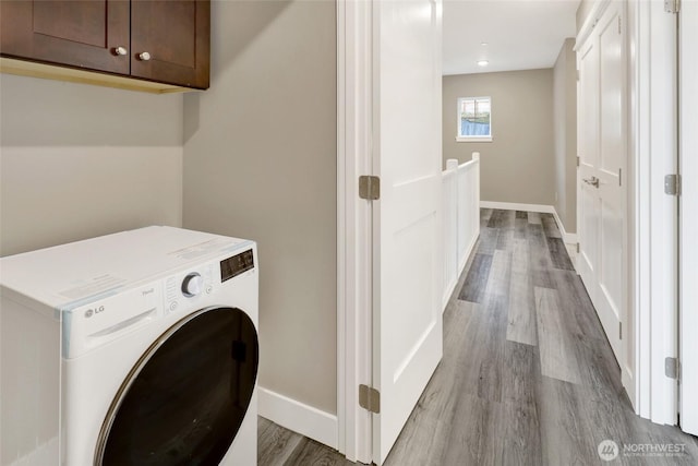 laundry area with washer / dryer, cabinet space, baseboards, and wood finished floors