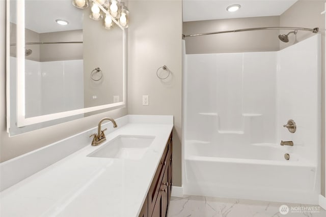 full bath with marble finish floor, washtub / shower combination, and vanity