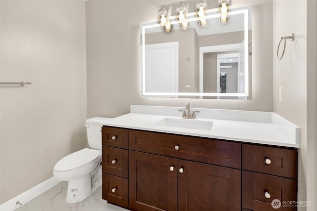 half bathroom featuring vanity, toilet, baseboards, and marble finish floor