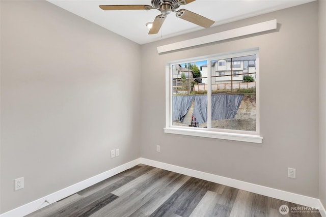 unfurnished room featuring baseboards, wood finished floors, and a ceiling fan