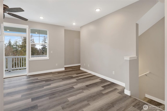 spare room with baseboards, wood finished floors, and ceiling fan