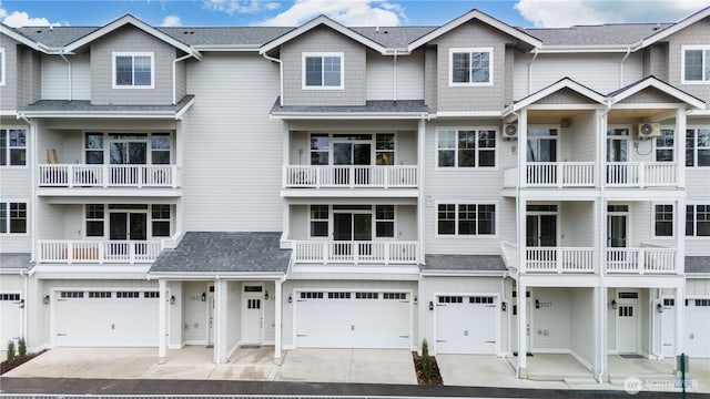 multi unit property with driveway, a shingled roof, and a garage