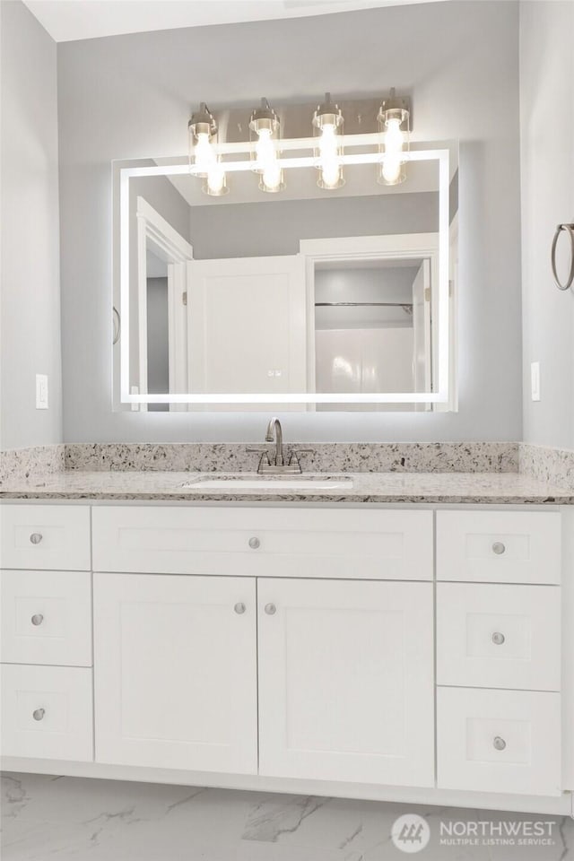 bathroom featuring marble finish floor and vanity