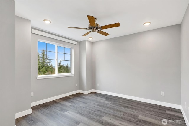 empty room featuring dark wood-type flooring, baseboards, and ceiling fan