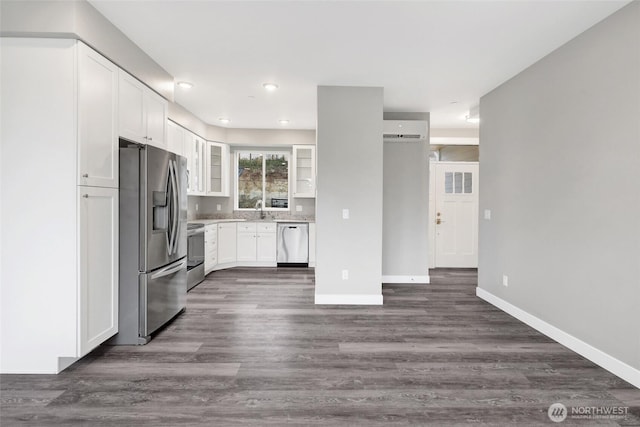 kitchen featuring glass insert cabinets, baseboards, white cabinets, stainless steel appliances, and a sink