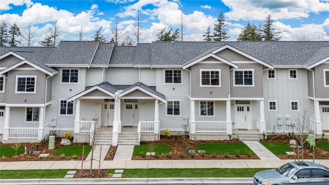 multi unit property featuring covered porch and a shingled roof