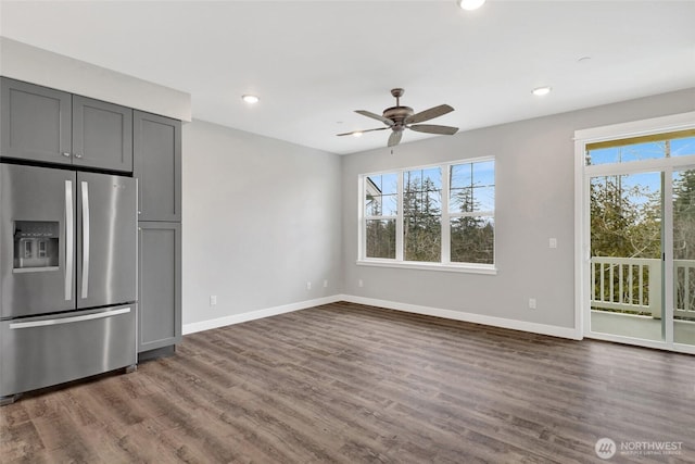 unfurnished dining area with baseboards, a healthy amount of sunlight, and dark wood-style floors