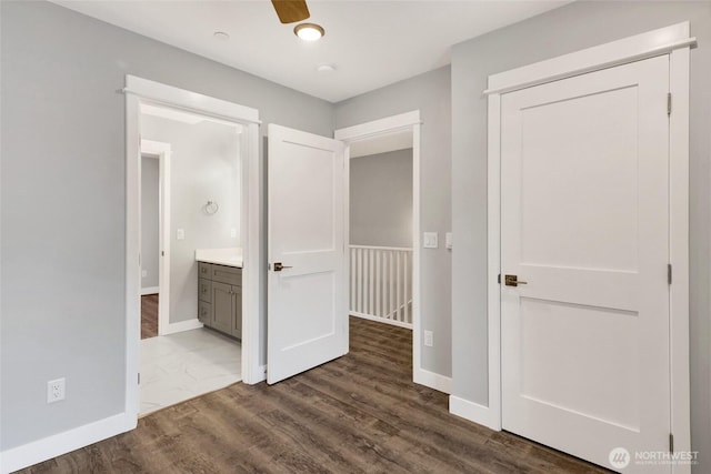 unfurnished bedroom featuring baseboards and dark wood-type flooring