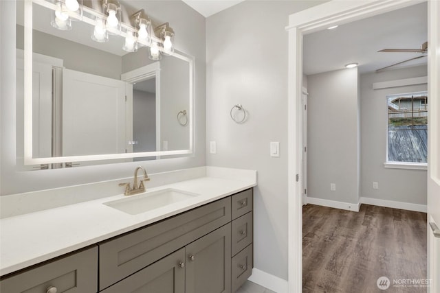 bathroom with vanity, wood finished floors, and baseboards