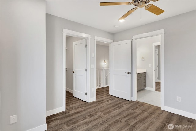 unfurnished bedroom with a ceiling fan, ensuite bathroom, baseboards, and wood finished floors