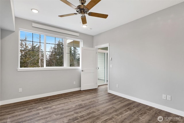 spare room with baseboards, wood finished floors, and a ceiling fan