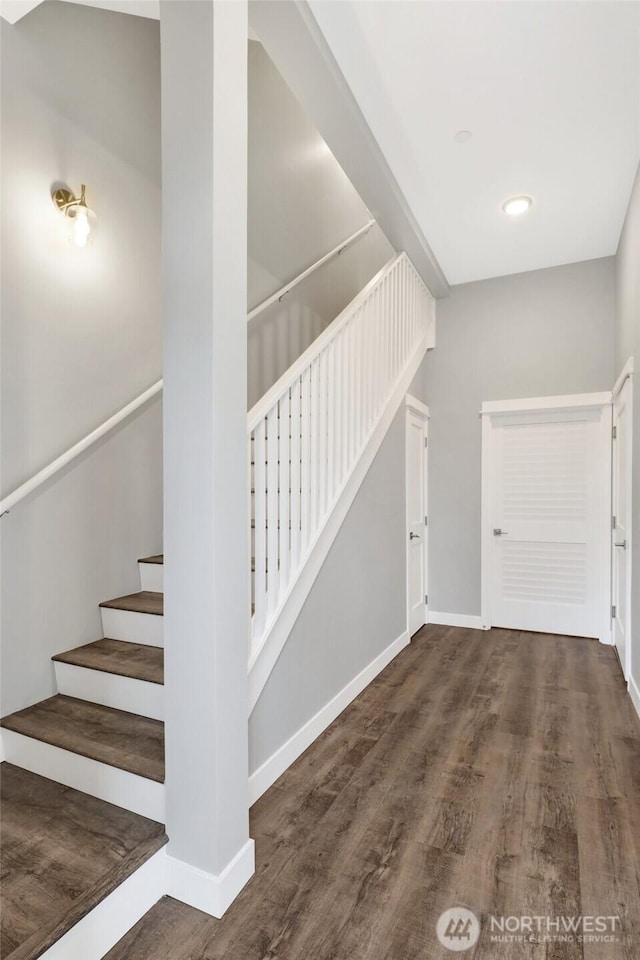 stairway with baseboards and wood finished floors