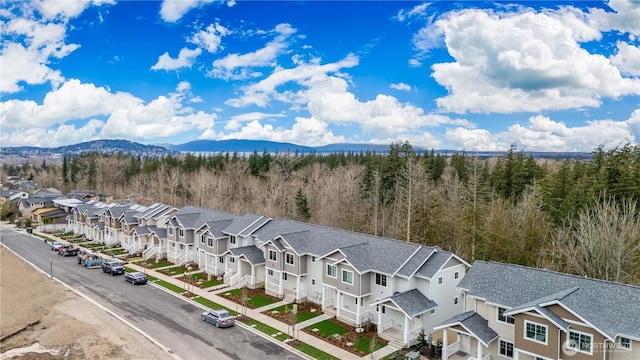 drone / aerial view featuring a mountain view, a residential view, and a view of trees