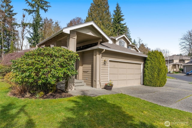 view of front of house featuring an attached garage, driveway, and a front yard