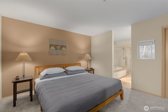 carpeted bedroom with ensuite bath and baseboards