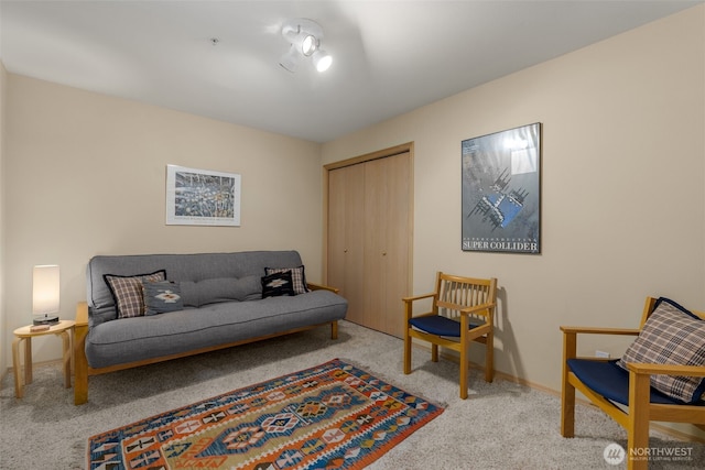 living area with baseboards and carpet