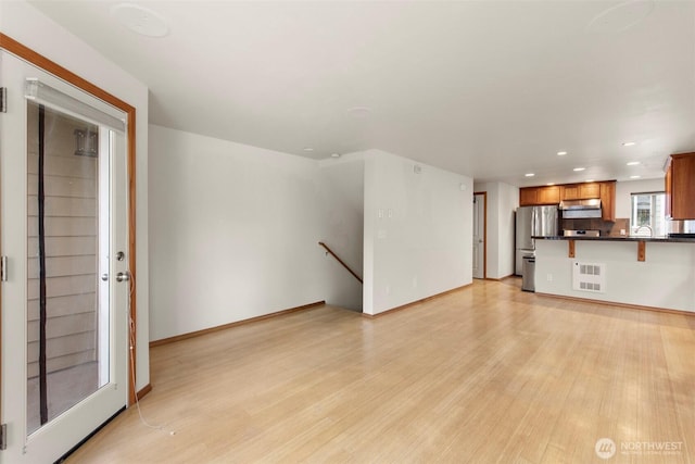 unfurnished living room featuring visible vents, recessed lighting, baseboards, and light wood-style floors