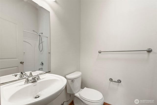 full bathroom featuring toilet, a shower, and a sink