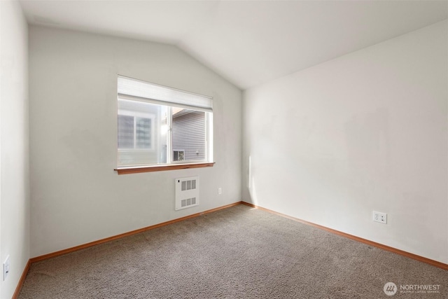 carpeted empty room with baseboards and lofted ceiling