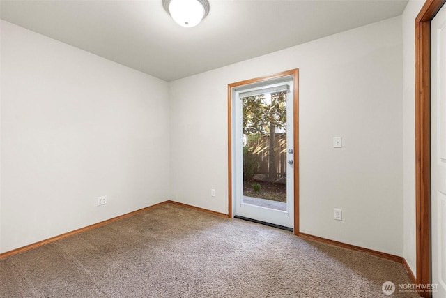 carpeted empty room featuring baseboards