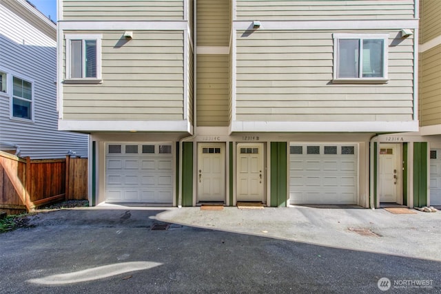 view of front of home with an attached garage and fence