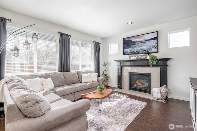 living area featuring dark wood finished floors, recessed lighting, a tiled fireplace, and baseboards