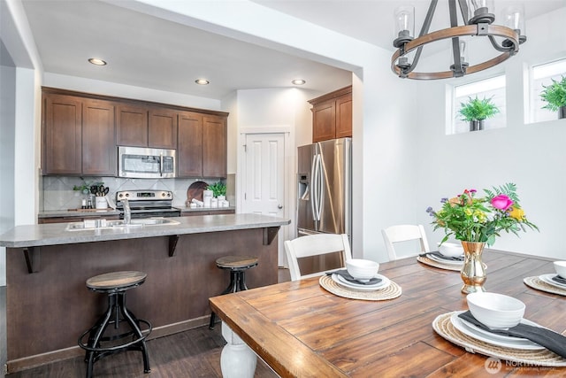 dining space featuring dark wood-type flooring, a notable chandelier, and recessed lighting