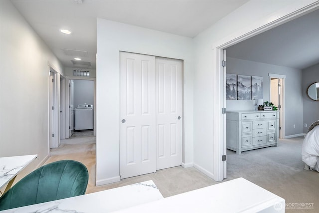 bedroom featuring washer / dryer, attic access, light colored carpet, and a closet