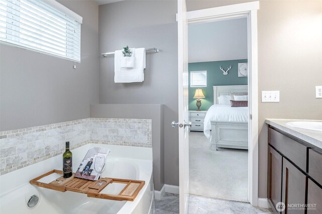 ensuite bathroom featuring vanity, a garden tub, and ensuite bathroom