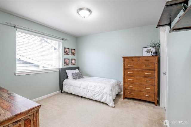 bedroom with light carpet and baseboards