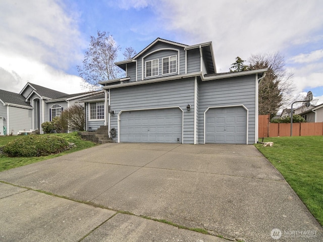 traditional home with a front yard, fence, a garage, and driveway