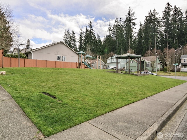 view of yard with a gazebo, a playground, fence, and a residential view